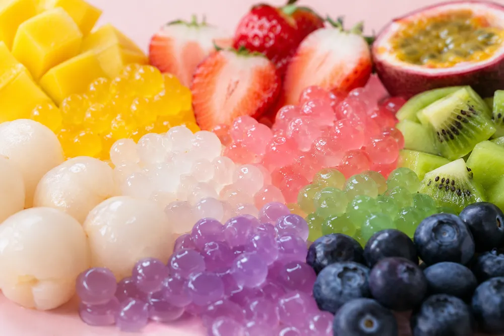 Fresh fruit and popping pearls arranged in a rainbow